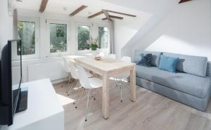 uma sala de estar com uma mesa e um sofá em Strandloft Eins Norderney em Norderney