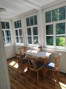 a dining room with a table and chairs and windows at Leśnik in Karpacz