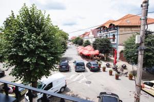 una strada cittadina con auto parcheggiate in un parcheggio di Fagaras City Center Experience a Făgăraş