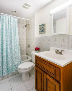 a bathroom with a toilet and a sink and a shower curtain at Beach Living at Island Pine Villas BLP in George Town