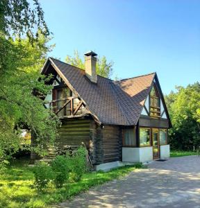 uma casa de madeira com um telhado de gambrel em Ceļinieks em Babīte