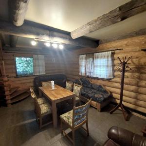 een woonkamer met een tafel en stoelen in een hut bij Ceļinieks in Babīte