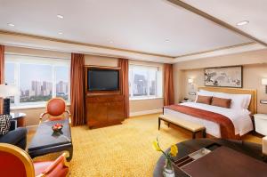 pokój hotelowy z łóżkiem i telewizorem w obiekcie The St. Regis Beijing w Pekinie