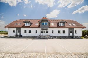 um grande edifício branco com um telhado vermelho em Apartment Rimljanček em Leskovec pri Krškem