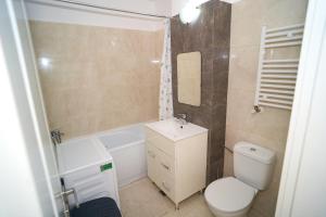 Baño pequeño con aseo y lavamanos en Stylish and Spacious Apartment in Iasi Fusion Towers, en Iaşi