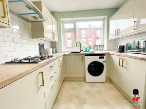 eine Küche mit einer Waschmaschine in der Mitte in der Unterkunft Oldham Newly Lovely 2BR 3Beds Bungalow UOLD158 in Moorside