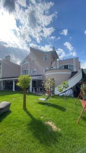 a large house with a boat on the lawn at Meduza Wellness Spa in Hlohovec