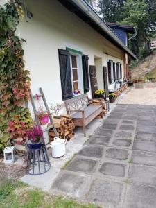 um alpendre de uma casa com um banco e flores em Monika am Masenberg em Vorau