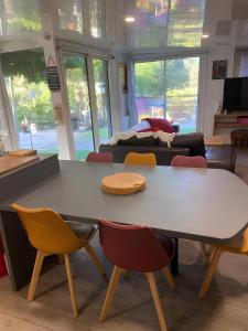 uma mesa e cadeiras numa sala de estar em La Paillotte - 6 personnes em Pommeret