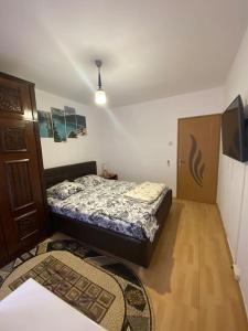a small bedroom with a bed and a wooden floor at Sunshine Faleza Nord in Constanţa