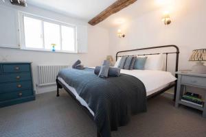 a bedroom with a bed and a dresser and a window at Linden Grove - 2 Bed City Centre Cottage in Kent