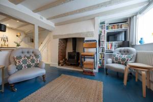 a living room with two chairs and a fireplace at Linden Grove - 2 Bed City Centre Cottage in Kent