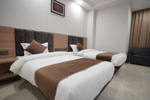 A bed or beds in a room at Hotel Krishna Inn