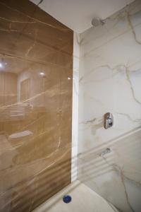 een badkamer met een douche en een glazen deur bij Hotel Krishna Inn in Jaipur