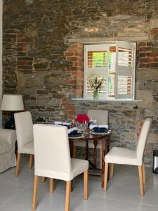 een eetkamer met een tafel en stoelen en een bakstenen muur bij The Garden Rooms at The Courtyard,Townley Hall in Drogheda