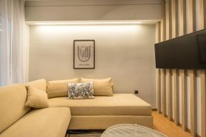 - un salon avec un canapé et une télévision dans l'établissement Urban suites- HELEXPO, à Thessalonique