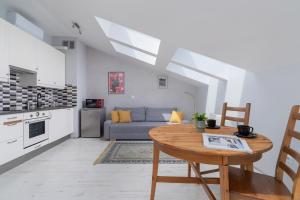 een keuken en een woonkamer met een tafel en een bank bij Sunny Studio Mostowa Krakow Kazimierz by Renters in Krakau