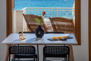 una mesa con un jarrón con una flor en el balcón en Beachfront Orange apt-Ligaria Beach en Lygaria