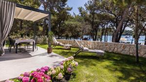 patio ze stołem, krzesłami i kwiatami w obiekcie Mare Solis Pinea w miejscowości Mali Lošinj