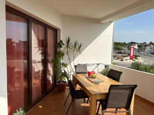 a wooden table and chairs on a balcony at Apartman Mrgic in Preko