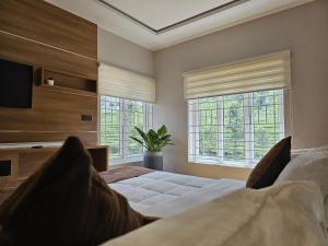 een slaapkamer met een groot bed en twee ramen bij Eagles Glide Resort in Pīrmed +62 foto's