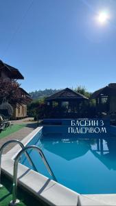 a swimming pool in a villa with a swimming pool at Садиба "ЯНА" in Slavske