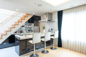 a kitchen with a counter and a staircase at Shibuya City House 渋谷シティハウス in Tokyo