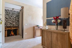 sala de estar con chimenea y mesa con flores en La Salentina Otranto - Happy Rentals, en Carpignano Salentino