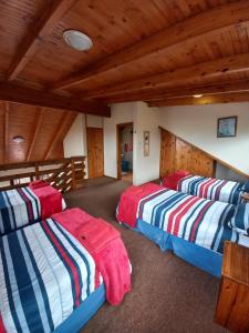 three beds in a room with wooden ceilings at Little Patch of Heaven in Port Alfred