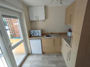 a small kitchen with a sink and a microwave at Sunset Retreat - Hunstanton in Hunstanton