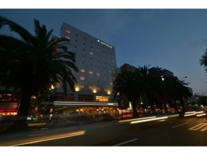 a tall building with palm trees in front of a street at Bright Park Hotel - Vacation STAY 67869v in Kochi