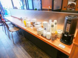 a counter in a restaurant with a coffee maker on it at HOTEL LiVEMAX Kobe Sannomiya in Kobe