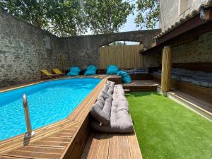 una piscina con terraza y un patio de césped en T3 bis bord du canal du midi piscine, en Homps