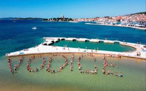 a group of people standing in the water on a beach at Tower House Vodice in Vodice