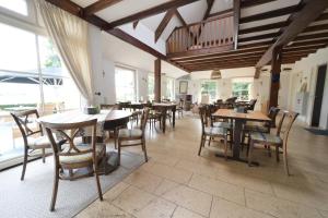 a dining room with tables and chairs and windows at B&B Stations Koffiehuis in Molkwerum