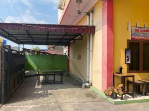 un edificio con toldo en el costado en Penginapan Steady Mitra RedDoorz en Pematangsiantar