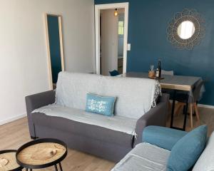 a living room with a couch and a table at Appartement avec vue mer in Vaux-sur-Mer