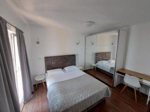 ein Schlafzimmer mit einem großen Bett und einem Spiegel in der Unterkunft R&N Apartment in Zavalatica