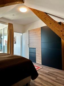 1 dormitorio con 1 cama y pared de madera en Wohnen über den Dächern von Bregenz, en Bregenz