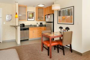 a kitchen with a wooden table and chairs in it at Residence Inn by Marriott Fredericksburg in Fredericksburg