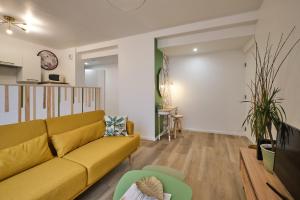 uma sala de estar com um sofá amarelo em Magnifique T3 centre ville avec WIFI RDC em Limoux