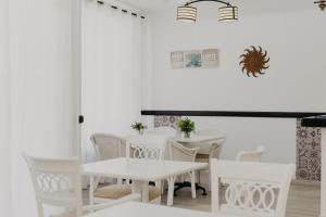 エステポナにあるMare Estepona Hotelの白いダイニングルーム(白い椅子、テーブル付)
