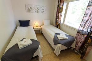 2 camas individuales en una habitación con ventana en Nord Riverside en Rovaniemi