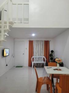 ein Wohnzimmer mit einem Tisch, Stühlen und einem Sofa in der Unterkunft Budget friendly yet cozy staycation in Calapan