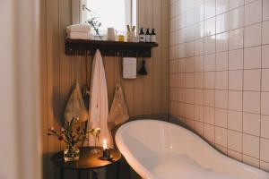 a bathroom with a tub and a candle on a table at Pariisin Ville in Porvoo