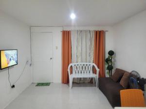 ein Wohnzimmer mit einem Sofa und einem Stuhl in der Unterkunft Budget friendly yet cozy staycation in Calapan