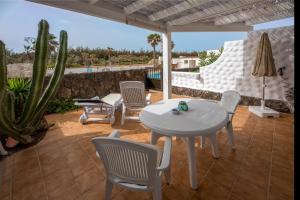 a patio with a table and chairs and a cactus at in front of the pool, large terrace, elegant & confortable, Wi-Fi in Costa Calma