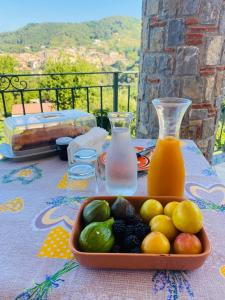 a tray of fruit on a table with a bottle of juice at B&B Girasole in Torraca