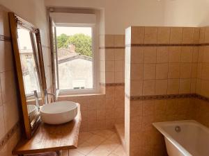 a bathroom with a sink and a tub and a window at Gîte Villa Blancal Location Vacances dans le Tarn 81 in Salvagnac