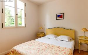 a bedroom with a bed and two windows at Lagrange Vacances Domaine de Fayence in Fayence
